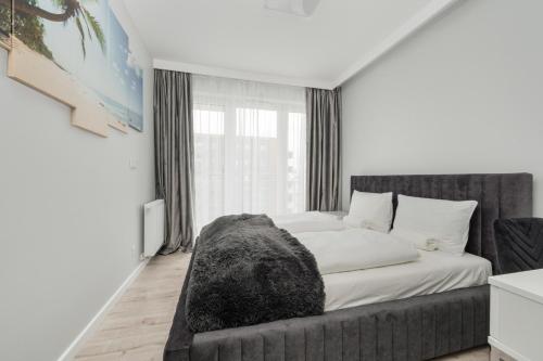a bedroom with a bed and a large window at Luksusowy Apartament z 3 Sypialniami, Klimatyzacją, Parkingiem i Biurkiem we Wrocławiu by Renters Prestige in Wrocław