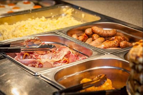 a buffet filled with different types of food in trays at Hotel Mare Blu -- boutique in Pineto