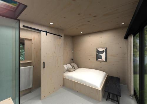 1 dormitorio con 1 cama en una pared de madera en Boetiekpark de Kas, en Scherpenzeel