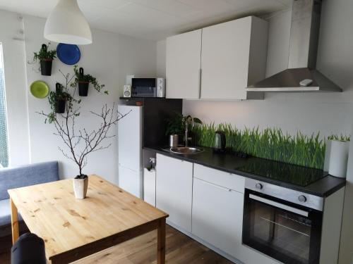 cocina con armarios blancos y mesa de madera en Charming apartment, en Borgarnes