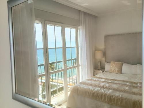 1 dormitorio con cama y ventana grande en Townhouse beachfront Benalmadena-Costa, en Benalmádena