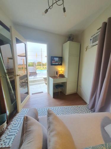 a room with a couch and a desk with a television at DELUXE ROOM BY THE POOL in Iba