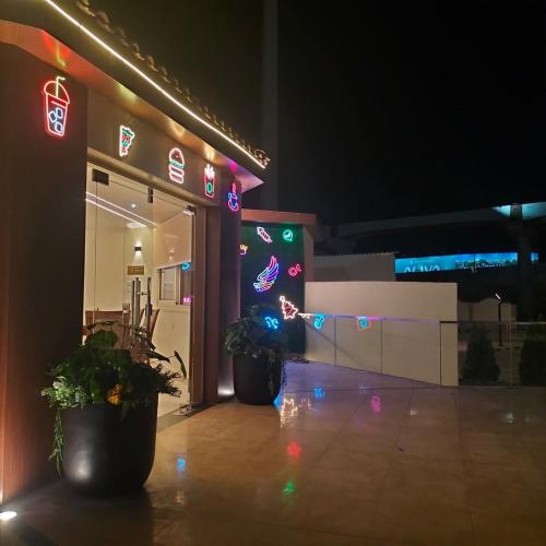 a building with two potted plants outside at night at Grand Plaza Hotel & Resort in Qaryat ash Shamālī
