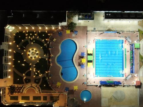 an overhead view of a swimming pool at night at Grand Plaza Hotel & Resort in Qaryat ash Shamālī