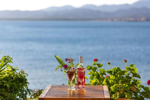 two bottles and a vase with flowers on a table at Sofia Ada in Fethiye