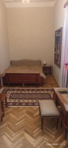 1 dormitorio con 1 cama y suelo de madera en Stone House, en Tskaltubo