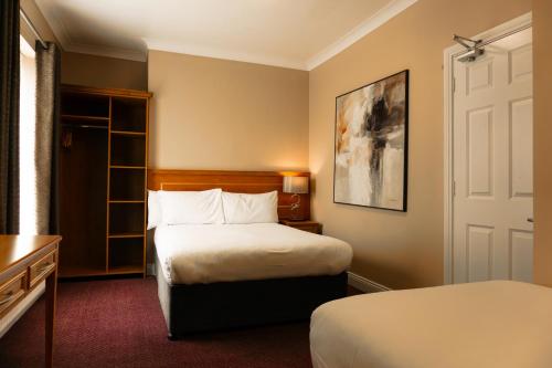 ダブリンにあるフェニックス パーク ホテルのベッド2台とドアが備わるホテルルームです。