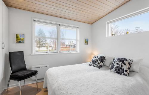 ein weißes Schlafzimmer mit einem Bett und einem Stuhl in der Unterkunft Amazing Home In Faaborg With Wifi in Bøjden