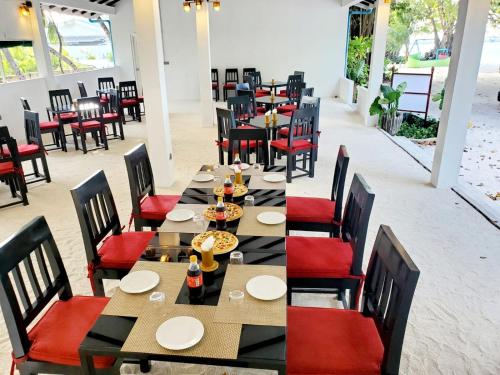 una sala da pranzo con tavoli e sedie con cibo sopra di Atholhu Beach club a Fehendhoo