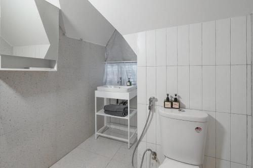 a white bathroom with a sink and a toilet at M Village Cửu Long in Ho Chi Minh City