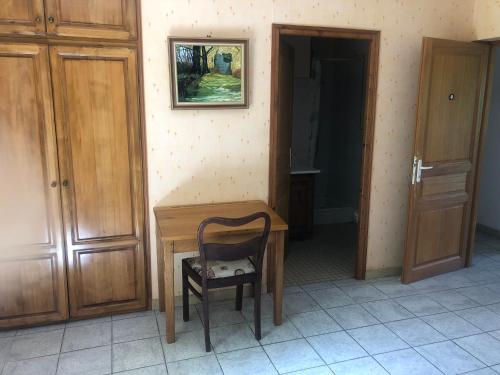 una sedia seduta su una scrivania in legno in una stanza di Chambres d hôte simone a Idrac-Respailles