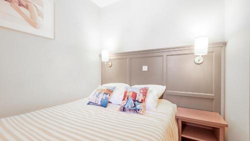 une chambre avec un lit avec deux oreillers dessus dans l'établissement Le PTIT DOUMÉ, Plage - Piscine, à Gassin