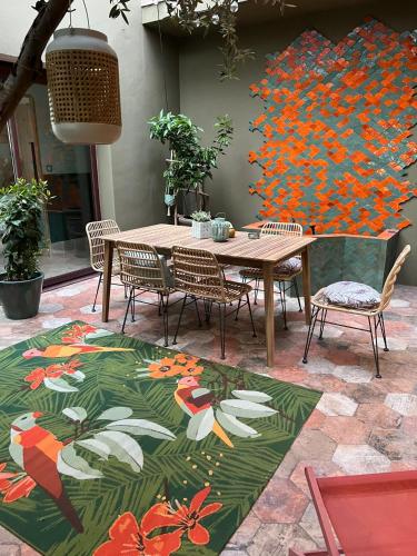 une table et des chaises avec un tableau de fleurs dans l'établissement Magnifique villa atypique de 230 m2 avec patio intérieur, à Sauvian
