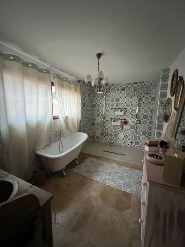 une salle de bain avec une baignoire blanche et un lavabo dans l'établissement Magnifique villa atypique de 230 m2 avec patio intérieur, à Sauvian