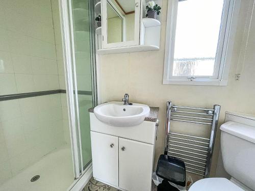 y baño con lavabo y ducha. en 8 Berth Caravan For Hire At Heacham Holiday Park In Norfolk Ref 21024f, en Heacham