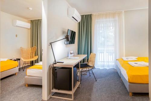 Habitación de hotel con 2 camas y escritorio en Tihany Yacht Club en Tihany
