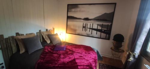 une chambre avec un lit avec une couverture rose dans l'établissement Chalet vue sur mer, à Saint-Martin-Plage