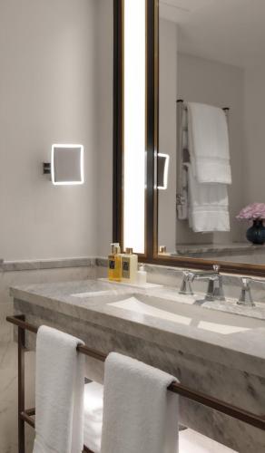a bathroom with a sink and a mirror and towels at The Biltmore Mayfair in London