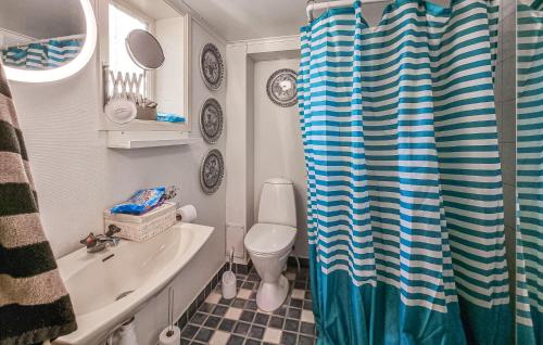 a bathroom with a sink and a toilet and a shower curtain at Cozy Apartment In Tjrn With Kitchen 
