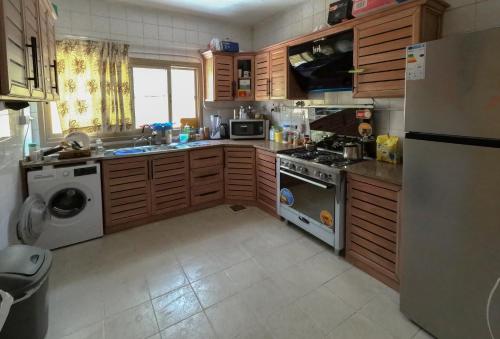 a kitchen with a refrigerator and a stove top oven at Extra Experiment in Aqaba