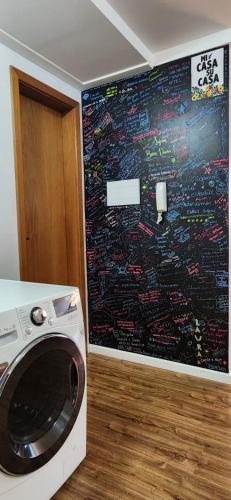 a washing machine in a room with a large screen at Apto BENTO! LAREIRA e CHURRASQUEIRA! in Bento Gonçalves