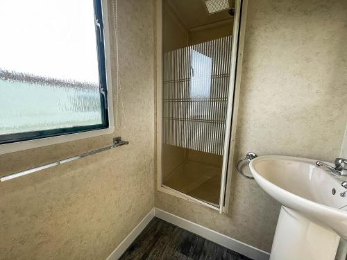 a bathroom with a sink and a glass shower at 8 Berth Caravan With Free Wifi At Heacham Holiday Park In Norfolk Ref 21008e in Heacham