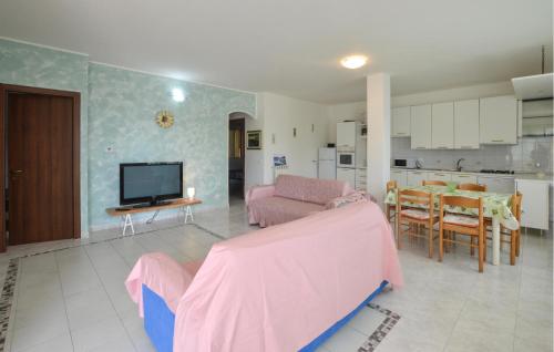 un soggiorno con divano rosa e una cucina di 3 Bedroom Cozy Apartment In Imperia a Imperia