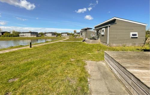 a house with a grass yard next to a body of water at Nice Home In Lauwersoog With Kitchen in Lauwersoog