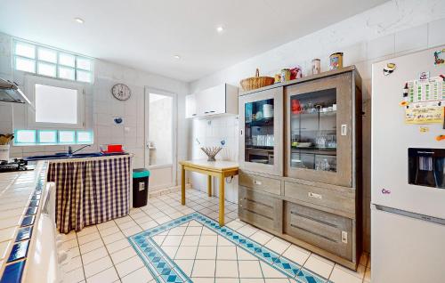 une cuisine avec un réfrigérateur et une table à l'intérieur dans l'établissement 3 Bedroom Gorgeous Home In Royan, à Royan