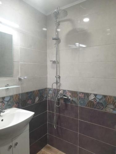 ein Bad mit einer Dusche und einem Waschbecken in der Unterkunft Къща за гости ОАЗИС in Ruse