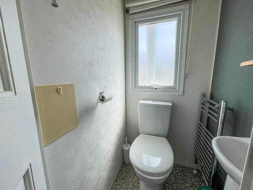 a bathroom with a toilet and a sink and a window at Lovely 8 Berth Caravan With Decking At Sunnydale Park, Lincolnshire Ref 35091br in Louth