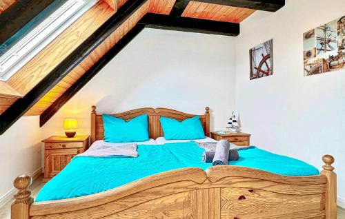 um quarto com uma cama de madeira e almofadas azuis em 2 Bedroom Beautiful Apartment In Dithmarschen em Friedrichskoog-Spitz