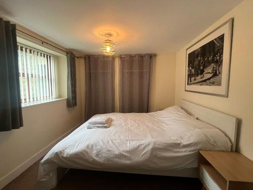a bedroom with a white bed and a window at Parkside in Pateley Bridge