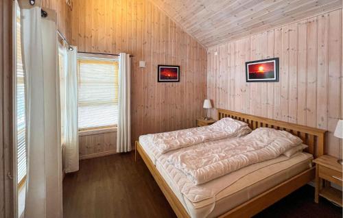 sypialnia z łóżkiem w drewnianej ścianie w obiekcie Gorgeous Home In Venabygd With House A Mountain View w mieście Venabygd