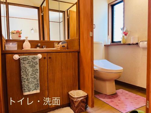 a bathroom with a toilet and a sink and a mirror at Yufuin Tsukawara Kogen Sanctuary - Vacation STAY 91378v in Yufuin