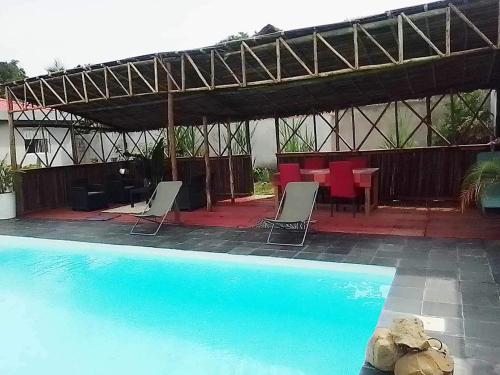 - une piscine avec des chaises, une table et une tente dans l'établissement Résidence Lilas Rose, à Andilana