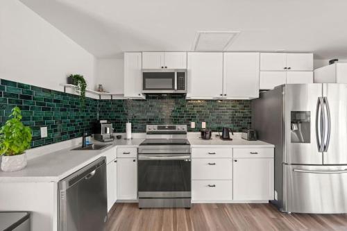 a kitchen with white cabinets and stainless steel appliances at Brand New 2Bed in Bonita's Heart with Superb Patio and Garden in Bonita Springs