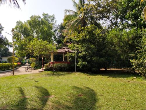 uma casa num parque com árvores e relva em Usha Resort em Pālghar