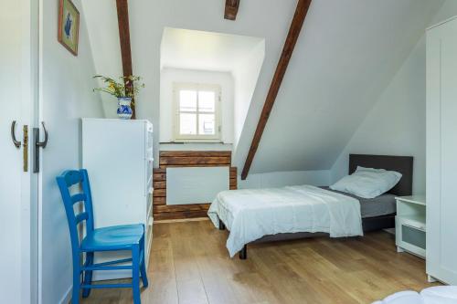 une chambre avec deux lits et une chaise bleue dans l'établissement Morgat, maison familiale, plage à pied, à Crozon