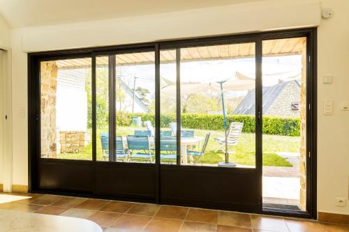 d'une porte coulissante en verre avec vue sur la terrasse. dans l'établissement Morgat, maison familiale, plage à pied, à Crozon