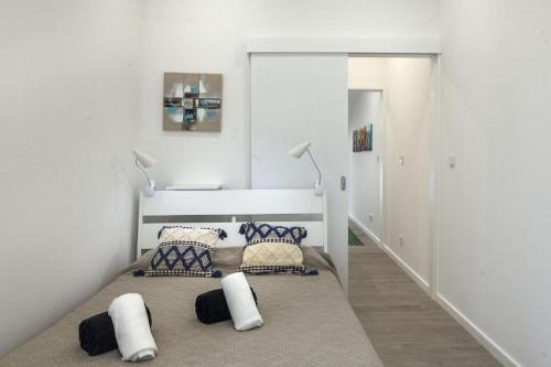 a room with a bed and pillows on a carpet at ANCO 56 - Cozy Retreat with Terrace in Ponta Delgada