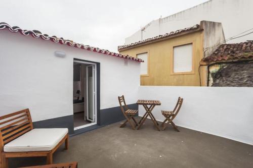 a patio with a table and chairs and a building at ANCO 56 - Cozy Retreat with Terrace in Ponta Delgada