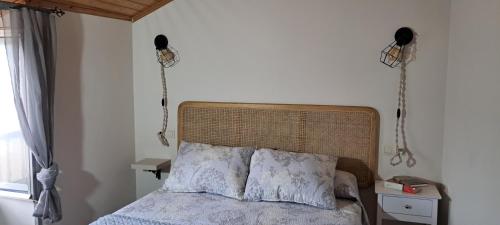 - une chambre avec un lit et 2 téléphones sur le mur dans l'établissement Casa fonte da pena, à Rinlo