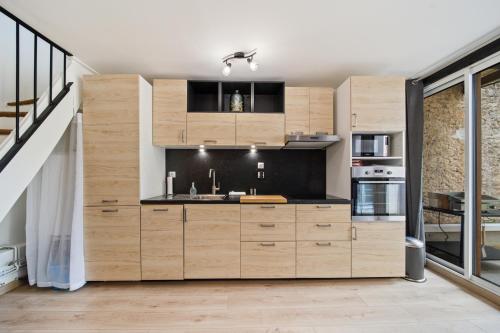 une cuisine avec des placards en bois et un escalier dans l'établissement LE DUPLEX, à Savigny-lès-Beaune