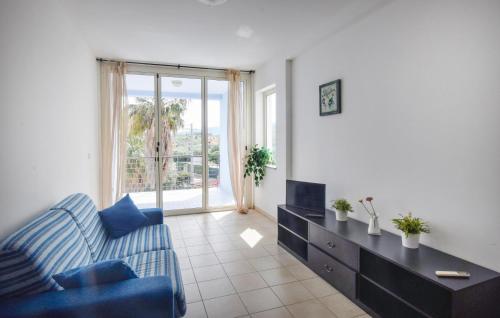 a living room with a blue couch and a table at Pet Friendly Apartment in Isca sullo Ionio