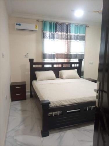 1 dormitorio con cama y ventana en 2 bedroom apartment, en Tema