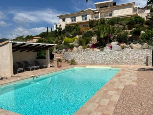 een zwembad voor een huis bij Studio 2 avec piscine & vue sur la baie d'Ajaccio in Alata