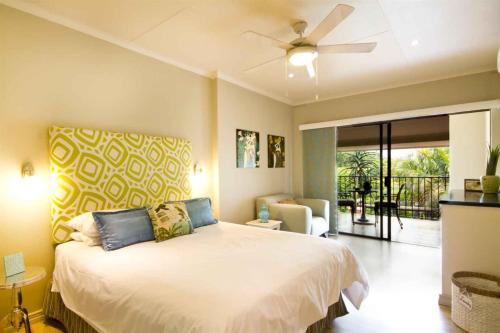 a bedroom with a bed with a ceiling fan at Malibongwe in East London