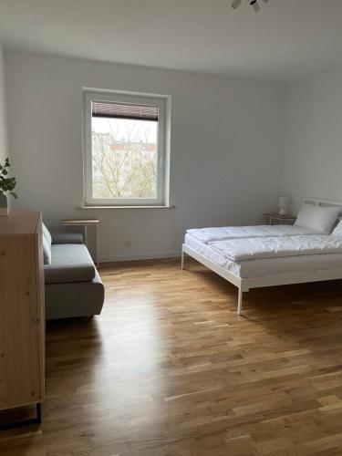 a white room with two beds and a window at Apartament Otwarta Wrocław in Wrocław