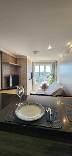 a room with a table with a plate and a bed at Apê BENTO com churrasqueira! in Bento Gonçalves